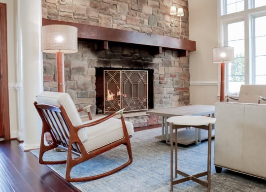 a living room with a fireplace and a table and chairs at Broadlands Apartments in Ashburn, VA 20148